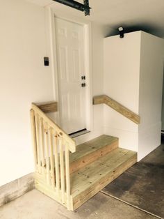 a wooden bench sitting in front of a white door next to a set of stairs