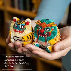 two small figurines in the palm of someone's hand with chinese characters on them