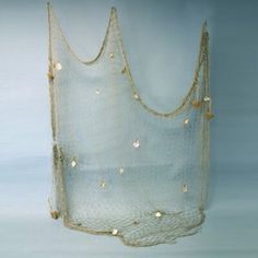 a white net with gold beads hanging from it's sides on a blue background