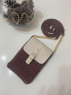 a brown and white purse sitting on top of a table next to a glass vase