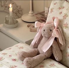 a stuffed animal sitting on top of a chair next to a table with a candle