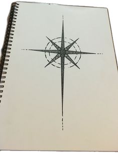 a spiral notebook with a compass drawn on it