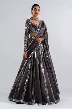 Black lehenga with real hand cut mirror embellishments. Comes with heavily embellished full sleeve blouse and mirror work dupatta.
Components: 3
Pattern: Embellished
Type Of Work: Mirrors
Neckline: V-Neck
Sleeve Type: Straight Full
Fabric: Lehenga and Dupatta - Satin Organza, Blouse - Georgette
Color: Grey
Other Details: 
Linear pattern mirror work
Tiny scalloped hem dupatta and lehenga
Back scoop neck with tassel tie-up
Closure: Blouse: Back hook-eye with tie-up
Occasion: Reception, Sangeet - A Grey Lehenga, Vani Vats, Mirror Work Lehenga, Lehenga Dupatta, Mirror Work Blouse, Black Lehenga, Full Sleeve Blouse, Grey Mirror, Georgette Dupatta