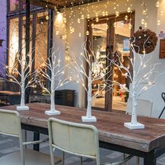 four white trees are sitting on top of a wooden table