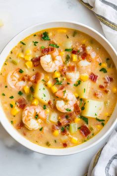 a white bowl filled with shrimp and corn chowee