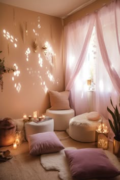 a living room filled with lots of pillows and candles next to a window covered in sheer curtains