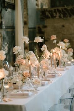 a long table with white flowers and candles