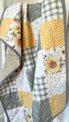 a yellow and gray quilt hanging on the wall