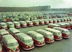 a parking lot filled with lots of red and white buses parked next to each other