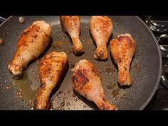 chicken legs are cooking in a pan on the stove