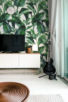 a living room with wallpaper and a guitar on the floor in front of it