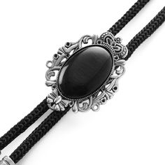 * Black cord with feather-shaped tips 
 * Adjustable sliding clasp
 * Stone looks like a Black Tiger’s Eye Elegant Adjustable Bolo Tie As A Gift, Vintage Black Jewelry With Adjustable Cord, Vintage Formal Jewelry With Adjustable Length, Vintage Jewelry With Adjustable Length For Formal Occasions, Elegant Concho Bolo Tie, Elegant Black Concho Jewelry, Gothic Style Adjustable Formal Jewelry, Silver Bohemian Bolo Tie With Adjustable Cord, Western Style Jewelry With Adjustable Chain