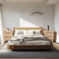 a bedroom with a bed, dressers and a potted plant in the corner