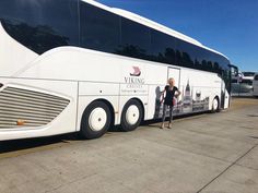 a man standing next to a large white bus