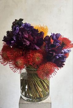 a vase filled with purple and yellow flowers