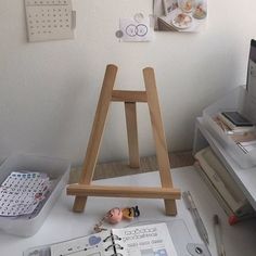 a wooden easel sitting on top of a white desk