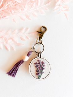 a keychain with a flower on it and a tassel hanging from the front