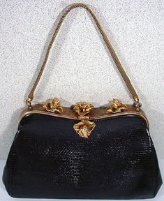 "We are pleased to off exclusively to our Etsy shoppers the wonderful Vintage Lizard Skin purse dating from the 1050's. The frame for the purse is in a gold tone finish with a hand tooled finish. There are three Iris Flowers on the top of the frame and a single Iris for the clasp All are accented with Sparkling Rhinestones and a mesh handle that also extends from the frame. Some wear to the finish of the gold coloring on the back part of the frame but, you really have to look hard to find it. Th Mid-century Gold Evening Bag, Vintage Formal Bags With Gold Clasp, Compact Evening Bags With Gold-tone Hardware, Vintage Bags With Gold-tone Hardware, Formal Compact Bag With Gold-tone Hardware, Compact Formal Bags With Gold-tone Hardware, Compact Formal Bag With Gold-tone Hardware, Vintage Evening Bag With Gold-tone Hardware, Gold Rectangular Bag For Luncheon