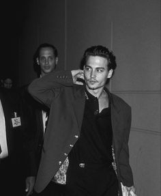 black and white photograph of two men in suits, one holding his jacket over his head