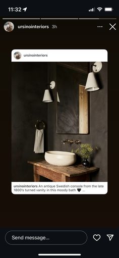 an image of a bathroom with black walls and white fixtures on the wall, along with a wooden vanity topped with a bowl sink