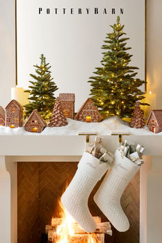 a fireplace with stockings hanging from it's sides next to a lit christmas tree