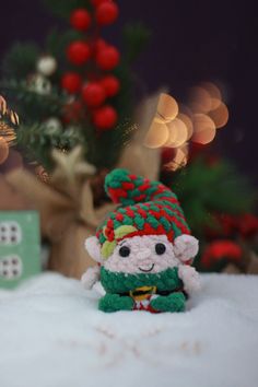 a small stuffed animal sitting in front of a christmas tree