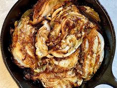 an iron skillet filled with cooked food on top of a table