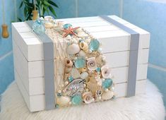 a white box filled with shells and seashells on top of a fur rug