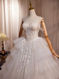 a white wedding dress is on display in front of a mannequin's head