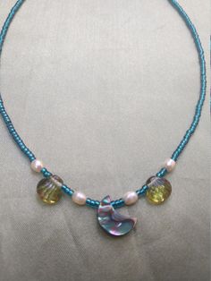 This delicate necklace has a oceany feeling. The pendent is made of abalone shell and is accented with white pearls and glass beads. Little blue seed beads bring it all together for a watery look. And it is finished off with a sterling silver  heart clasp. Handmade Blue Pendant Pearl Necklace, Handmade Blue Pearl Pendant Necklace, Blue Beaded Necklace With Pearl Drop For Gift, Celestial Blue Beaded Necklaces, Blue Mother Of Pearl Jewelry For Beach, Blue Shell Beaded Necklaces, Blue Beaded Necklaces With Pearl Pendant, Handmade Blue Abalone Shell Necklaces, Blue Beaded Necklace With Pearl Pendant