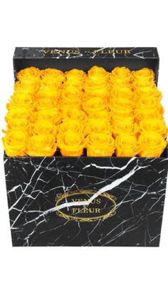 a black box filled with yellow roses