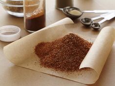 a table topped with lots of spices and utensils on top of a cutting board