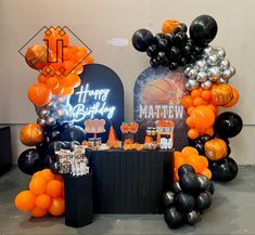 an orange and black birthday party with balloons