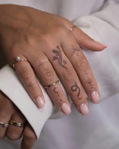 a woman's hand with tattoos on her fingers and the word love written in cursive writing