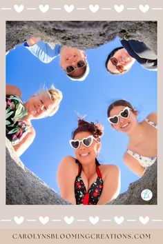 four people are standing in the middle of a heart shaped hole with sunglasses on their faces