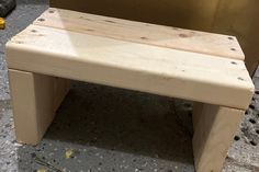 a wooden bench sitting on top of a cement floor