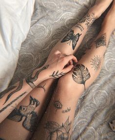 a person with tattoos on their legs laying down