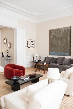 a living room filled with furniture and a painting on the wall above it's fireplace