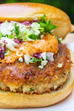 crispy chicken burgers with ground chicken and coleslaw on a white plate