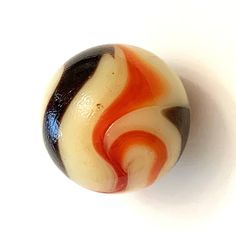 an orange, black and white swirl bead on a white background with room for text