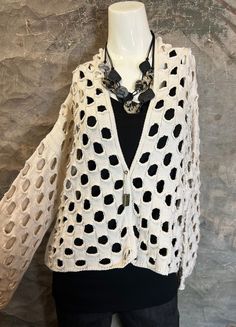 a white sweater with black polka dots on it