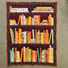 a quilted book shelf with many books on it