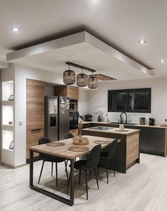 an open kitchen and dining room area with wood flooring, white walls and ceiling