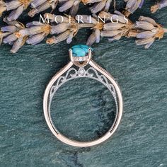 a close up of a ring on a rock with flowers in the background and text morning