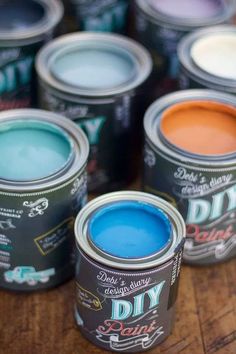 several cans of paint sitting on top of a wooden table