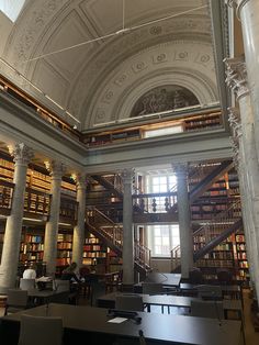 the interior of a library with many bookshelves and tables in front of them