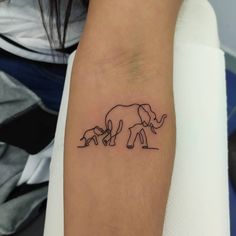 an elephant and her baby are depicted on the arm, which is drawn in black ink