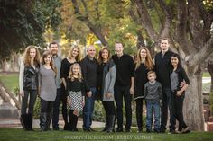 a family poses for a photo in front of some trees