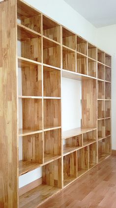 an empty room with wooden shelves and hard wood flooring