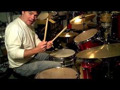 a man sitting in front of a drum set